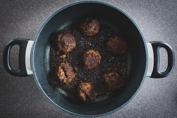 plant-based food, vegan meatballs made of black beans mushroom mince and textured vegetable protein getting pan fried