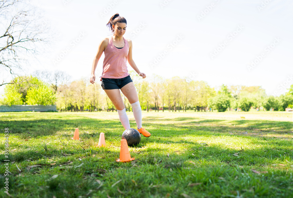 Canvas Prints Young female soccer player practicing on field.