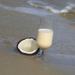 A glass cup of caribbean coconut rum on the beach. Coquito.
