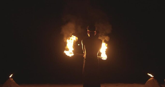 Man show of fire on the beach at night time