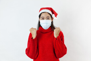 Fototapeta na wymiar Excited young asia woman Santa girl in red sweater, Christmas hat isolated on white background. Mock up copy space. Clenching fists like winner