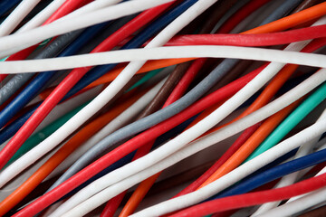 Many multi-colored wires lying in workshop closeup background. Laying of electrical and computer networks concept