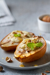 Baked pears with ricotta, nuts and honey on a plate