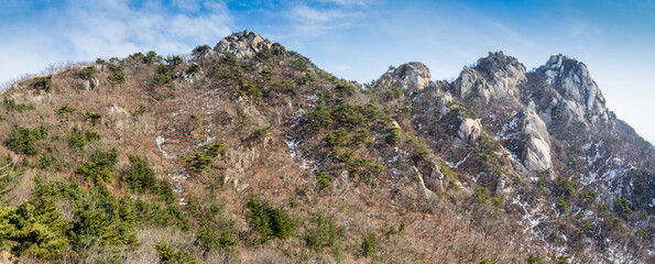 Fototapeta na wymiar Panorama of Bukhansan Mountain national park with rocks, snow, and dead trees in the spring in Seoul of South Korea.