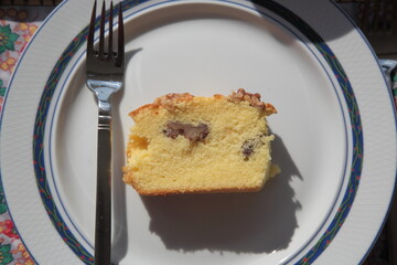 View of homemade orange walnut cake with fork under sunlight in plate on table  in Vancouver, British Columbia, Canada.