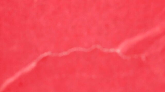 Red paper with tear marks as background. Selective focus.