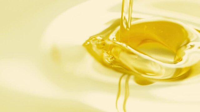 Close-up pouring golden olive oil liquid in slow motion, healthy food background