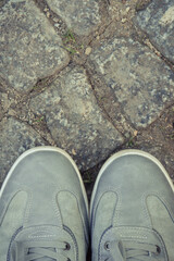Gray leather shoes for men on footpath made of rocks or stones. Male footwear. Copy space for text