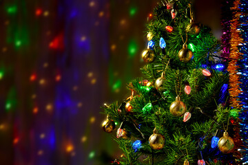 Fototapeta na wymiar Decorated green Christmas tree on a semi-blurred background with bright lights