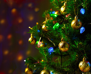 Christmas tree decorated with blue and green lights on a semi-blurred background of lights