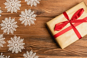 top view of winter snowflakes and present on wooden 