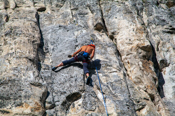 Active life, rock climbing, man rock climber climbing the challenging route on the rocky wall