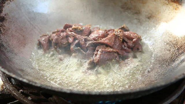 Frying pork liver in pan, Chiangmai Thailand