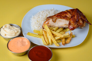 Pollo asado al espiedo con arroz, papa y salsas