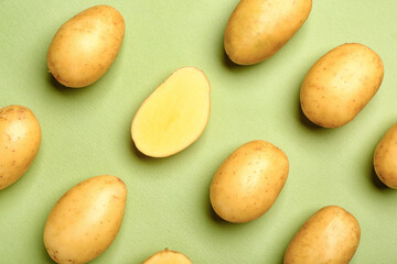 Raw potatoes on color background