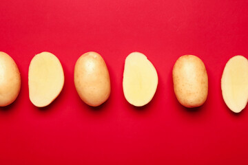 Raw potatoes on color background