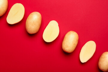 Raw potatoes on color background