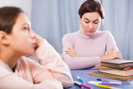 Mother talking seriously with her teenage daughter about poor school performance