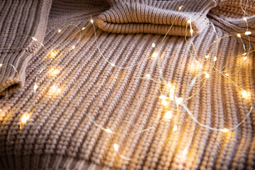 Knitted fabric background with glowing garland