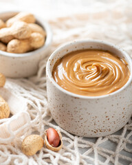 peanut butter in a ceramic bowl on a light background