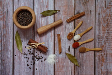 Flat lay of various colorful herbs and spices on wooden background