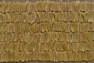 A background of rows of raw finely chopped noodles laid out tightly to each other on linen canvas