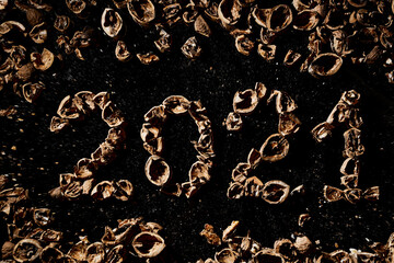 New year numbers 2021 are laid out from walnut shells on a black mirror background. Healthy and healthy food. Useful trace elements