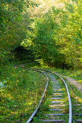 Abandoned railway in autumn mountain forest with foliar trees in Caucasus, Mezmay