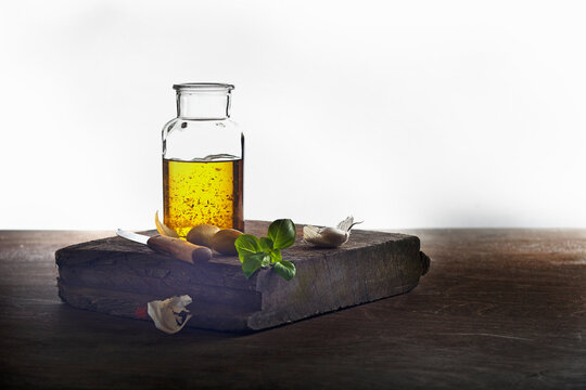 Basil oil with garlic on a rustic wooden board