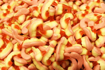 Colorful texture using as background. A lot of sweets. Background 3d rendering illustration. Orange and black multiple jelly candies in powdered sugar. Confectionery wallpaper concept. Copy space