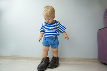 small child, dressed in brown shoes large adult. the child wore dad's shoes