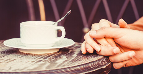 Couple enjoying coffe. Lovely couple holding cup of coffe in hands. Female and man hands holding cup of coffee