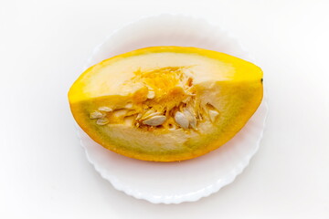 A piece of pumpkin in close-up on a white ceramic plate on a white background. Focus in the center