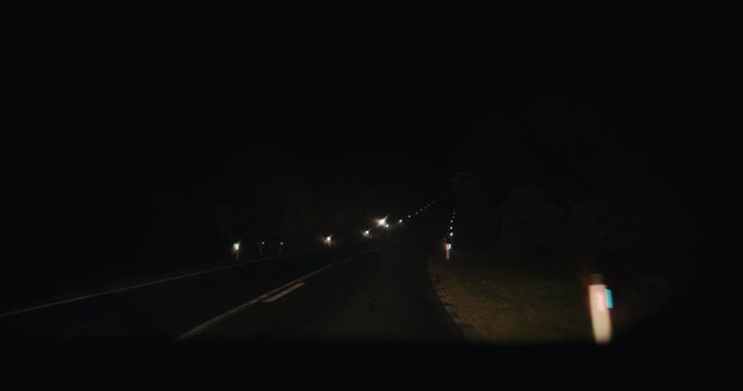 Car drive on empty road dark autumn night pov wipers clean rain fall