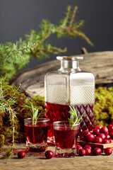 Cranberries and cranberry liquor on an old wooden table.