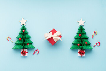 Christmas card - Xmas paper green tree, snowflakes, candy canes and gift boxes on blue background.