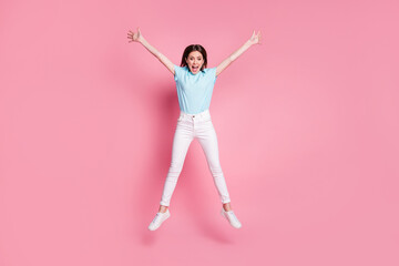 Full size photo of amazed crazy girl jump raise hands star wear gumshoes isolated over pink color background