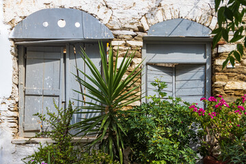 Fototapeta na wymiar Fenster mit Blumen im Bergdorf Pirgos auf der griechischen Kykladeninsel Tinos