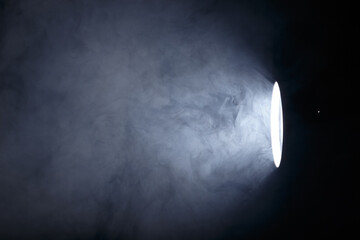 flashlight or spotlight through the smoke. Light beam on a dark background. Haze