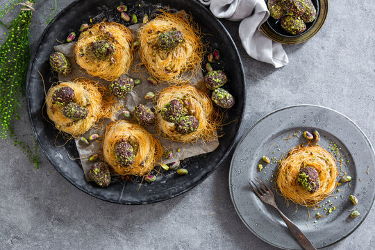 Easter eggs coated in dates, cocoa and pistachios in angel hair pasta nests