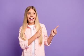 Photo of impressed long hairdo pretty girl point empty space wear pink shirt isolated on violet...
