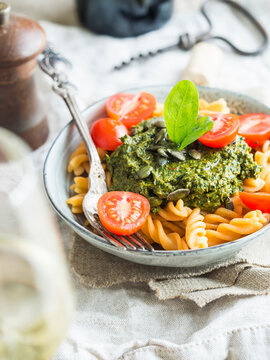 Vegan green pesto with dried tomatoes, seved with gluten-free red lentil fussili pasta