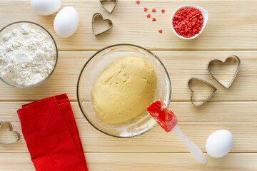 Step by step recipe of making cookies for valentine's day. Finished shortbread dough in glass bowl on wooden background