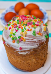 Easter cake with marzipan on a white plate on the background of dyed chicken eggs