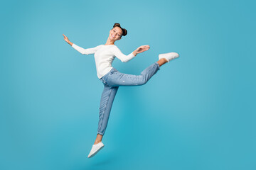 Full length photo of girl jump dance ballet wear white sweater jeans sneakers isolated blue color background