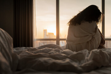 After sleepless night sad woman got up sit on bed thinking, lost in sad thoughts about irreparable mistake decision, feeling remorse, break up in relations with beautiful sunlight in the morning.