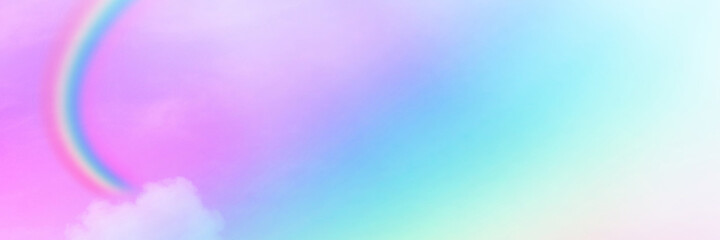 The Rainbow sky is Colorful sky with Soft clouds and a rainbow crossing. Fantasy magical sunny sky pastel background is fluffy white cloud. Freedom wallpaper concept. Sweet color dream.