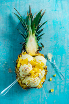 Pineaple and coconut sorbet in a pineapple with pineaple chunks and toasted coconut