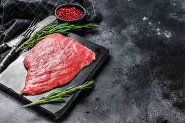 Flat iron steak. Raw Marble beef meat black Angus. Black background. Top view. Copy space