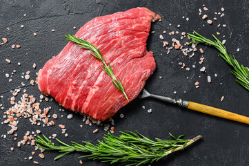 Raw Flat iron steak with rosemary and pink salt. Fresh Marble beef meat black Angus. Black...